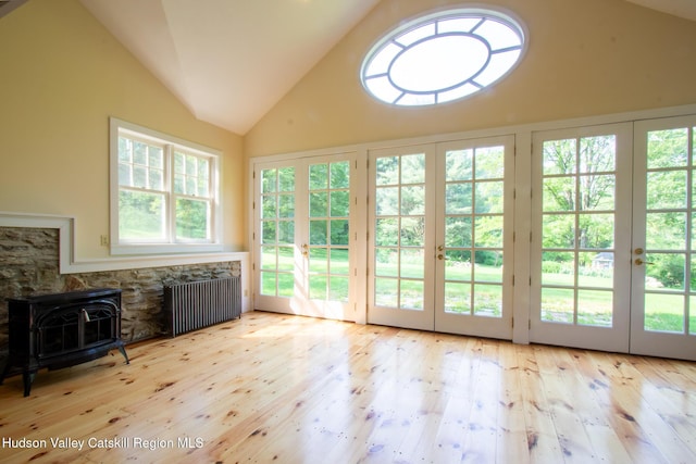 477 Fog Hill Rd, Austerlitz, NY 12017 - unfurnished sunroom featuring french doors, radiator, vaulted ceiling, and a wood stove