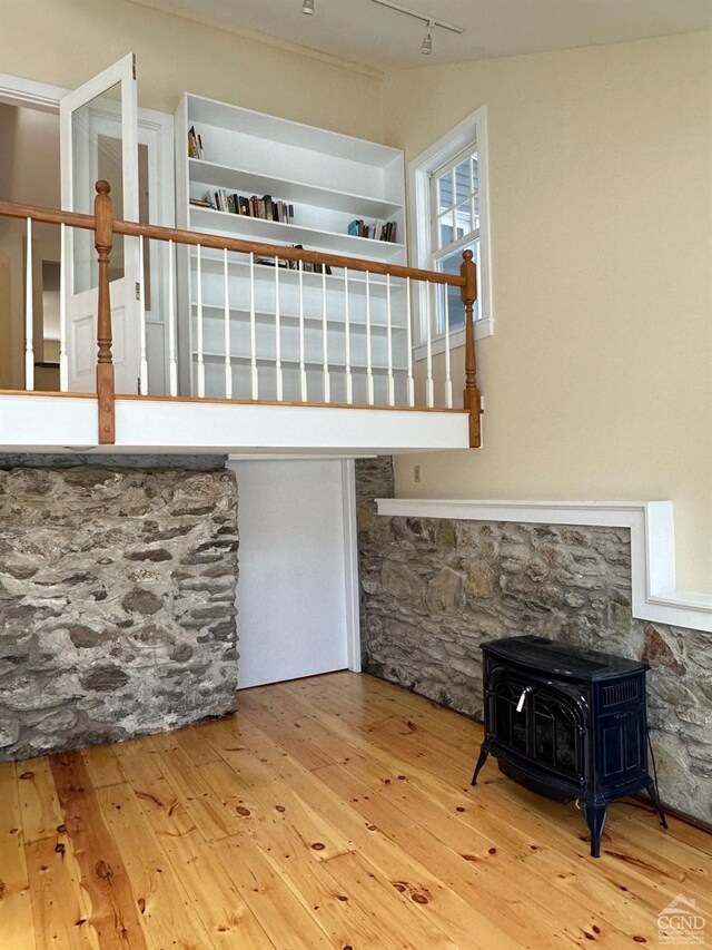 477 Fog Hill Rd, Austerlitz, NY 12017 - unfurnished living room featuring a wood stove, wood-type flooring, and track lighting