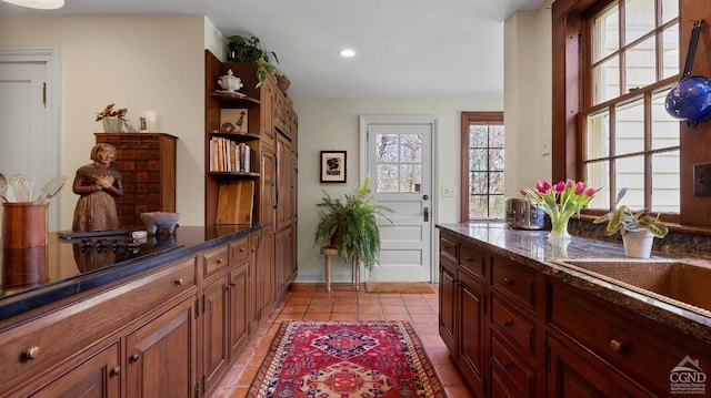 doorway with recessed lighting, light tile patterned floors, and a sink