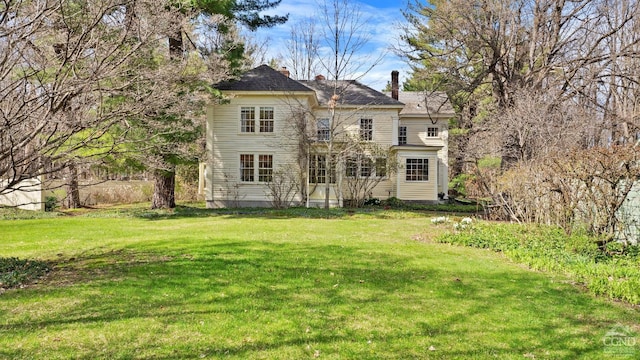 rear view of house with a lawn and a chimney