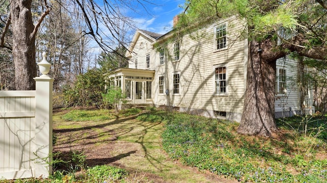 view of side of home with a sunroom and a chimney