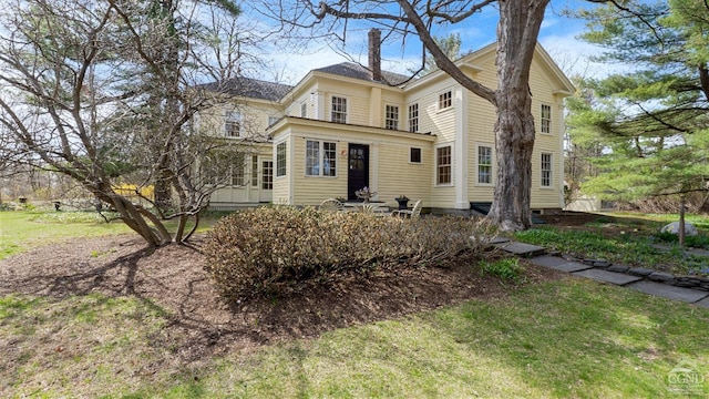 view of front of property featuring a chimney and a front lawn