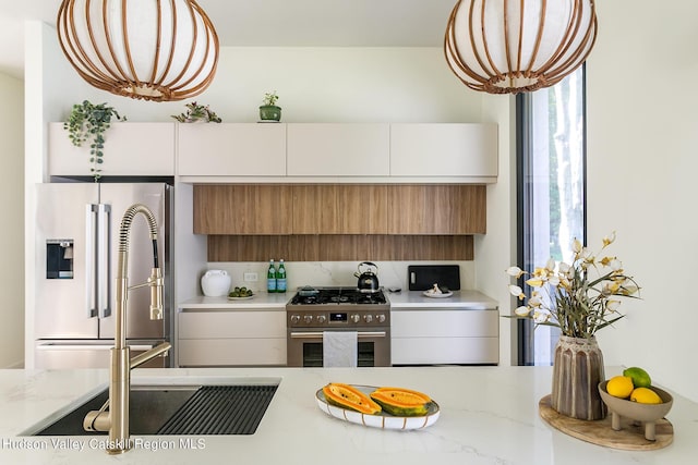 8 Accurso Rd, Saugerties, NY 12477 - kitchen featuring light stone counters, brown cabinets, appliances with stainless steel finishes, and modern cabinets
