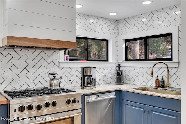 kitchen featuring light stone countertops, appliances with stainless steel finishes, blue cabinets, and sink