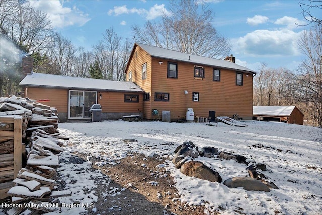 snow covered rear of property with cooling unit