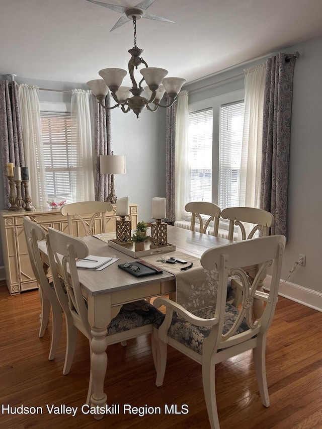 dining room with baseboards, light wood finished floors, and a chandelier