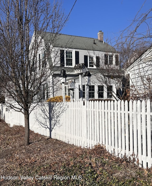 view of front of home featuring a fenced front yard and a chimney