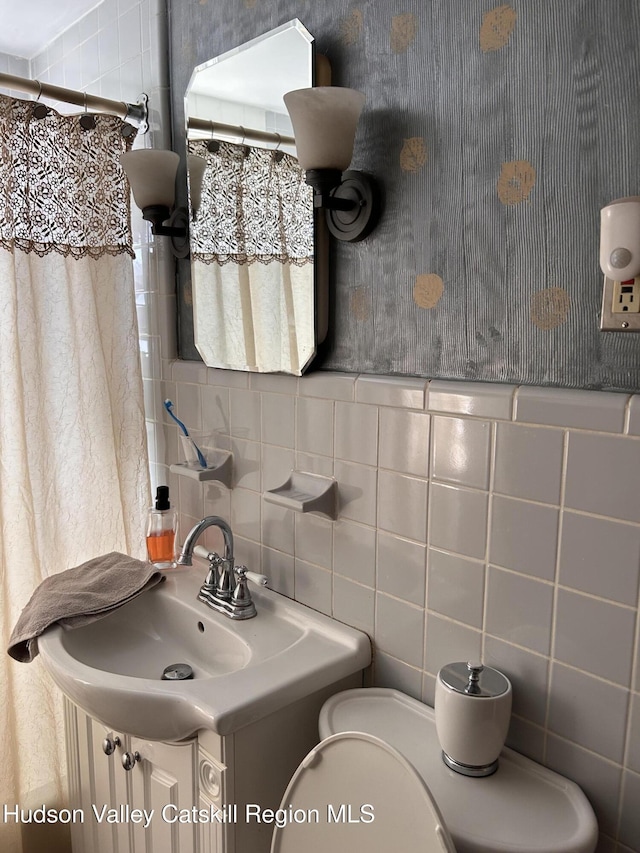 bathroom with toilet and tile walls