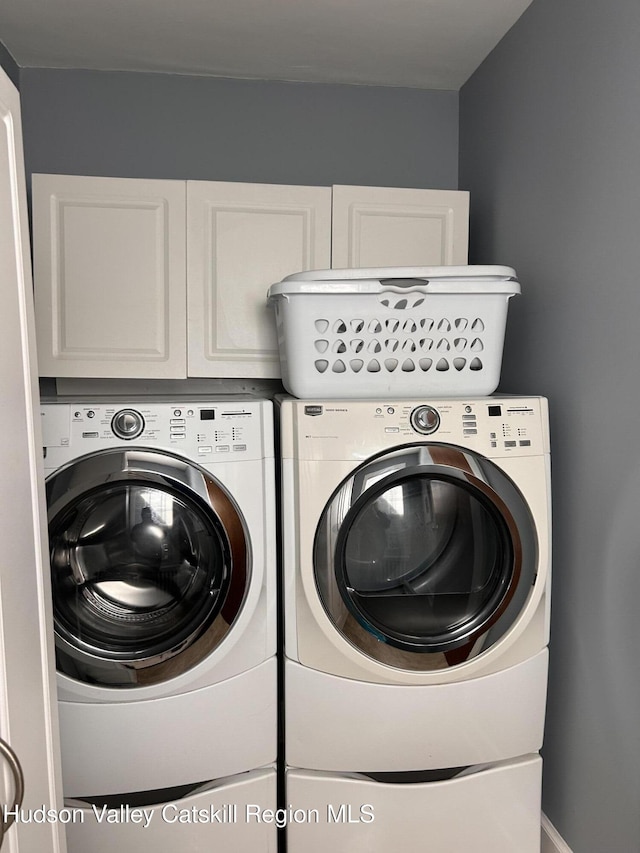 washroom with cabinet space and washing machine and dryer