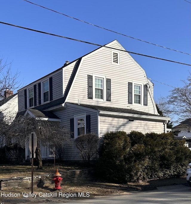 view of side of property featuring a gambrel roof