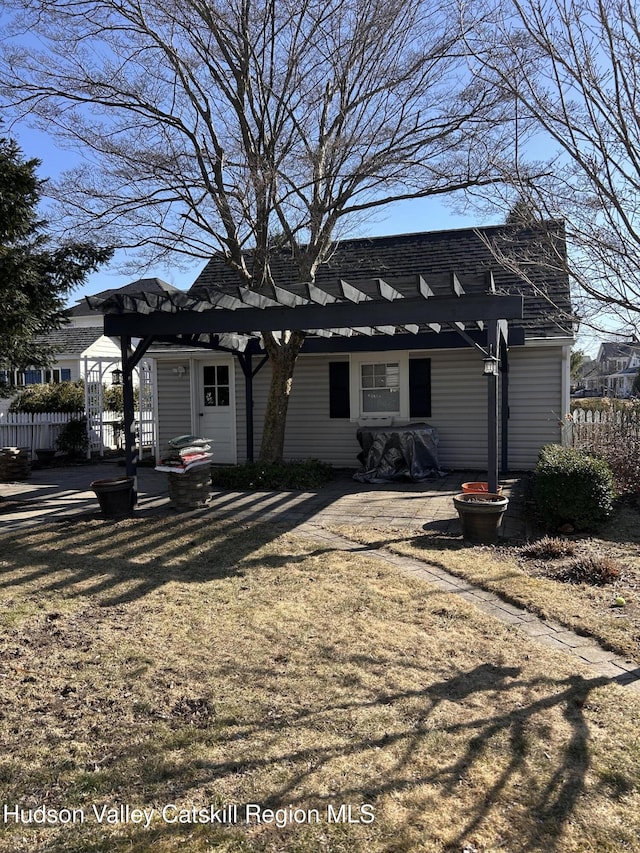 back of property with fence and a pergola