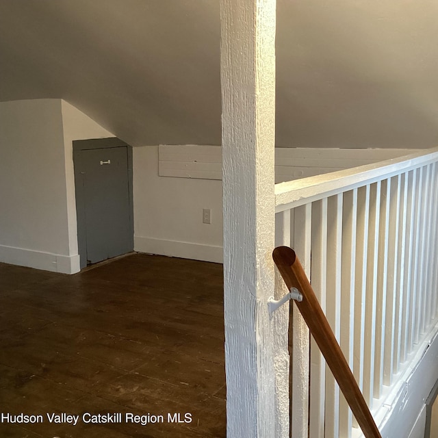 bonus room with dark wood-type flooring and vaulted ceiling