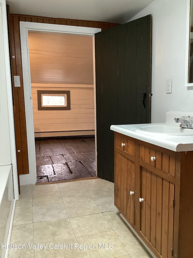 bathroom with vanity, a tub to relax in, tile patterned floors, and baseboard heating