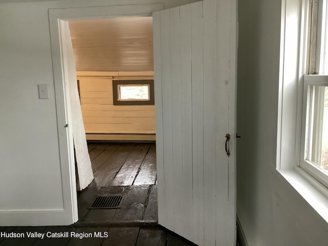 hallway featuring wooden walls and dark hardwood / wood-style flooring