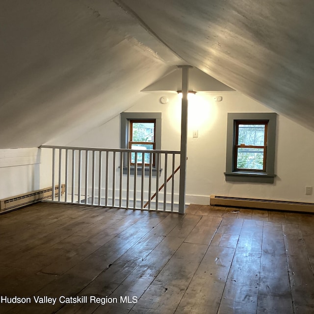 additional living space featuring lofted ceiling, dark hardwood / wood-style floors, and baseboard heating