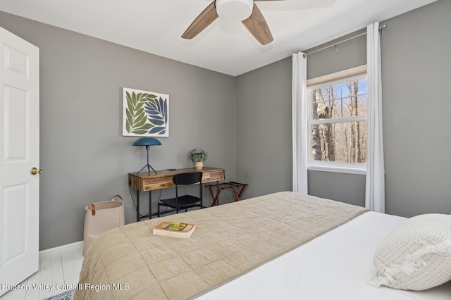 bedroom with baseboards, wood finished floors, and ceiling fan