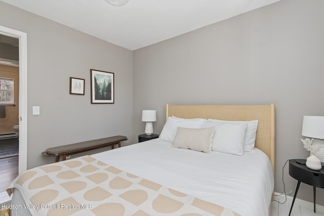 bedroom with baseboards and wood finished floors