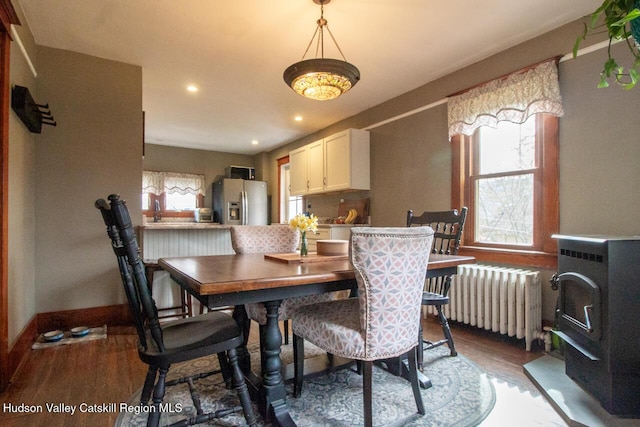 22 Hill St, Napanoch, NY 12458 - dining room featuring radiator heating unit, wood finished floors, a wood stove, and recessed lighting