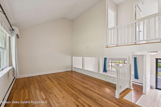 6 Stevens Ct, Saugerties, NY 12477 - unfurnished living room featuring baseboard heating, wood finished floors, lofted ceiling, and healthy amount of natural light