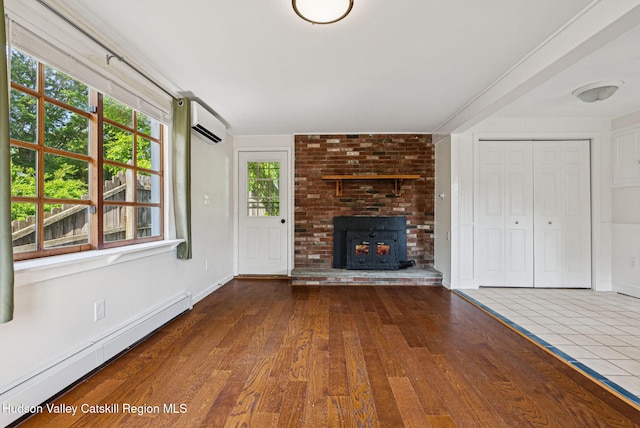 6 Stevens Ct, Saugerties, NY 12477 - unfurnished living room featuring baseboard heating, a wall mounted AC, and wood-type flooring