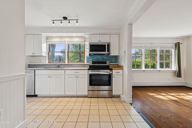 6 Stevens Ct, Saugerties, NY 12477 - kitchen featuring appliances with stainless steel finishes, a sink, baseboard heating, white cabinetry, and backsplash