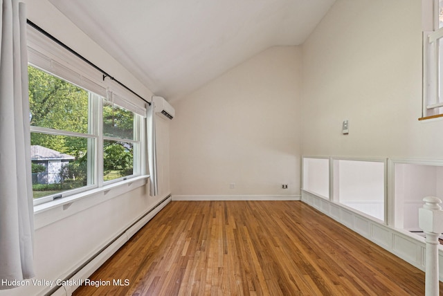 6 Stevens Ct, Saugerties, NY 12477 - empty room with lofted ceiling, wood finished floors, a baseboard radiator, a wall unit AC, and baseboards