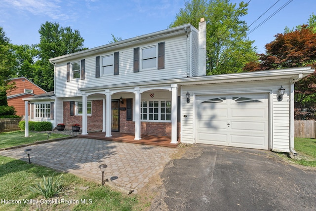 6 Stevens Ct, Saugerties, NY 12477 - traditional home with covered porch, a chimney, asphalt driveway, and brick siding