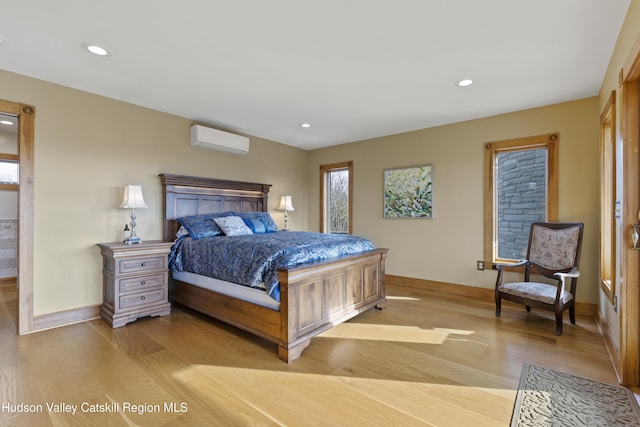 bedroom featuring light hardwood / wood-style flooring and an AC wall unit