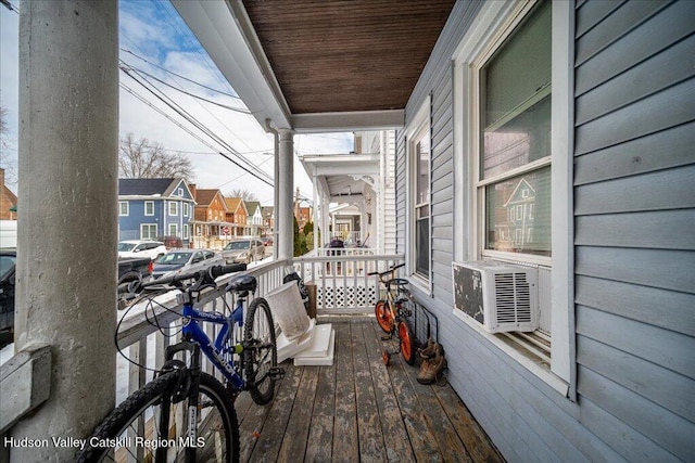 balcony featuring a porch, cooling unit, and a residential view