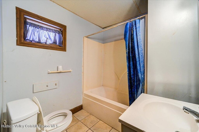 bathroom with toilet, shower / bath combo with shower curtain, a sink, baseboards, and tile patterned floors