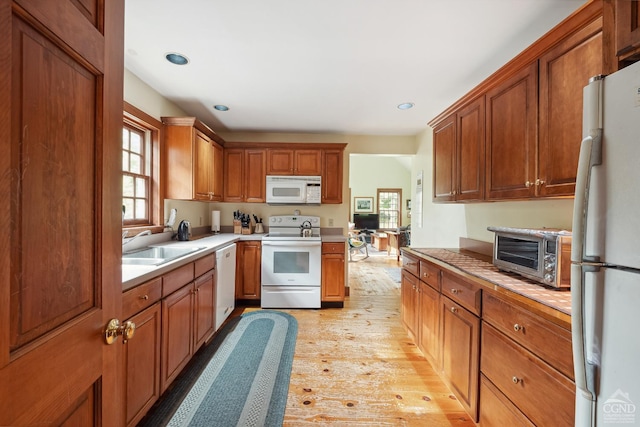 2205 County Route 5, Canaan, NY 12029 - kitchen with white appliances, light wood-type flooring, a sink, light countertops, and brown cabinetry