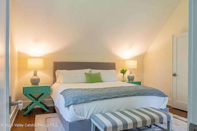 bedroom with vaulted ceiling and dark wood-type flooring