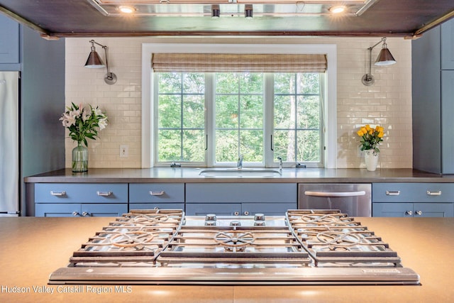 kitchen with stainless steel appliances, sink, and backsplash