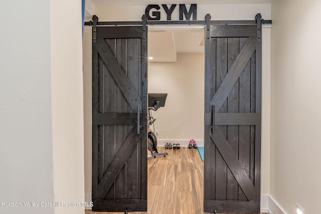 interior space with wood-type flooring and a barn door