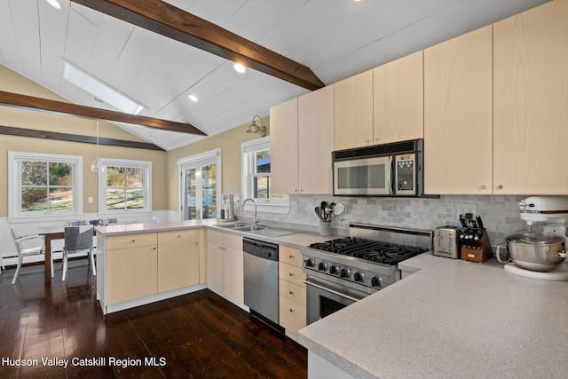 kitchen featuring a peninsula, stainless steel appliances, light countertops, decorative backsplash, and dark wood-style floors