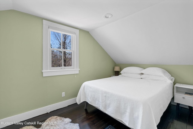 bedroom with lofted ceiling, wood-type flooring, and baseboards