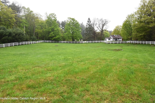view of yard featuring fence and a rural view