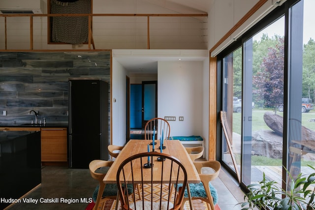 1199 W Highland Rd, Hobart, NY 13788 - dining area featuring a wall mounted AC, a towering ceiling, and concrete floors