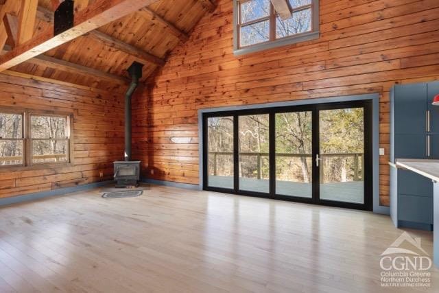 269 Church Ave, Germantown, NY 12526 - unfurnished living room featuring wooden walls, wooden ceiling, light wood-type flooring, a wood stove, and beam ceiling