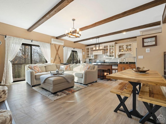 23 Townhouse Ln Unit D 1, Windham, NY 12496 - living area with a chandelier, a wall unit AC, beamed ceiling, and light wood-style flooring