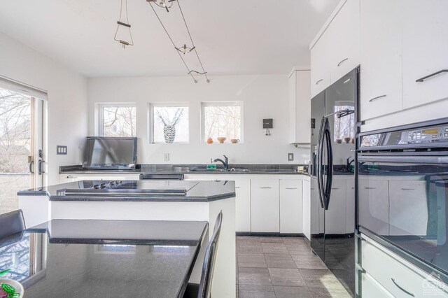 219 Sleepy Hollow Rd, Athens, NY 12015 - kitchen featuring a sink, black appliances, dark countertops, white cabinets, and a center island