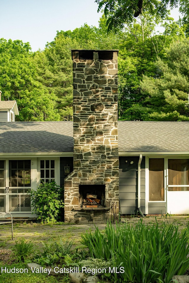 19 Dug Rd, Accord, NY 12404 - detailed view of an outdoor stone fireplace, a chimney, roof with shingles, and a downspout