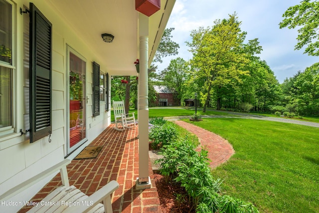 view of grassy yard with covered porch