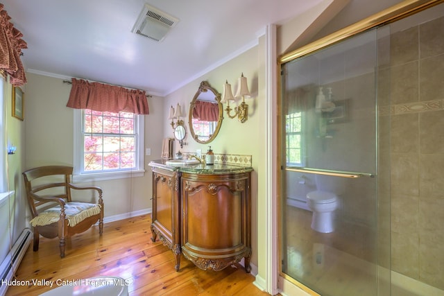 bathroom featuring a baseboard radiator, wood-type flooring, crown molding, a stall shower, and vanity
