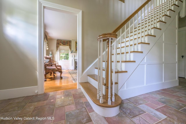stairs featuring stone tile floors and baseboards
