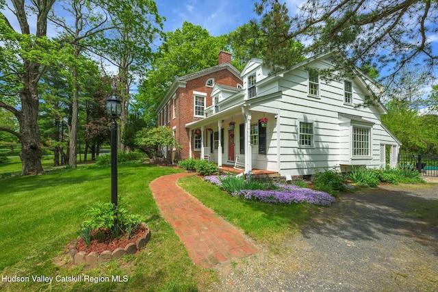 view of front facade featuring a chimney and a porch