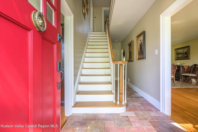 staircase featuring stone finish flooring and baseboards