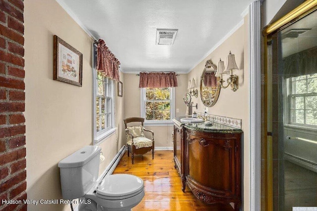 bathroom with a baseboard radiator, wood finished floors, ornamental molding, toilet, and vanity
