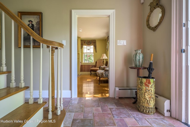 entrance foyer featuring stairway, baseboards, stone finish flooring, and baseboard heating