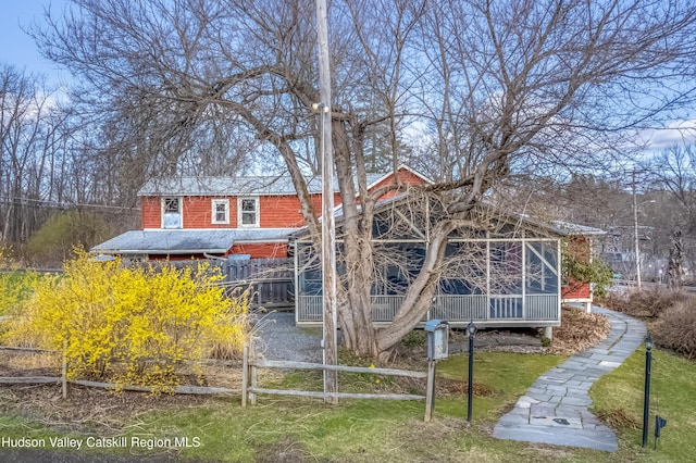 back of property with a yard, roof with shingles, and fence